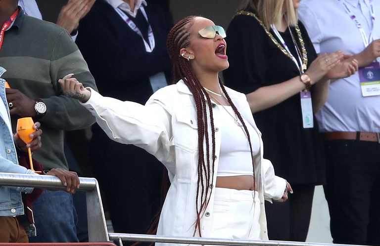 Rihanna(centre) reacts as she watches match from same level as the player balcony.
